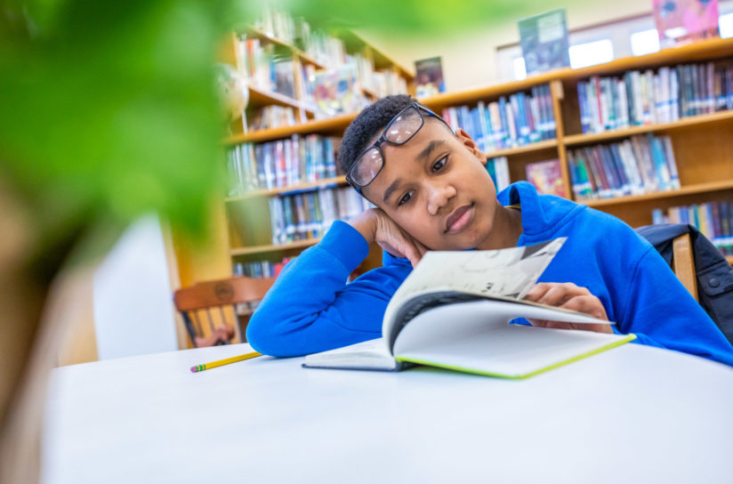 A student reading a book in the library