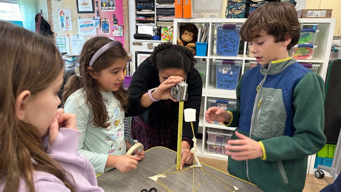 Students gathered around a desk for STEAM class